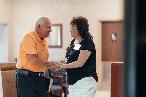 A greeter warmly welcoming a guest at Oasis